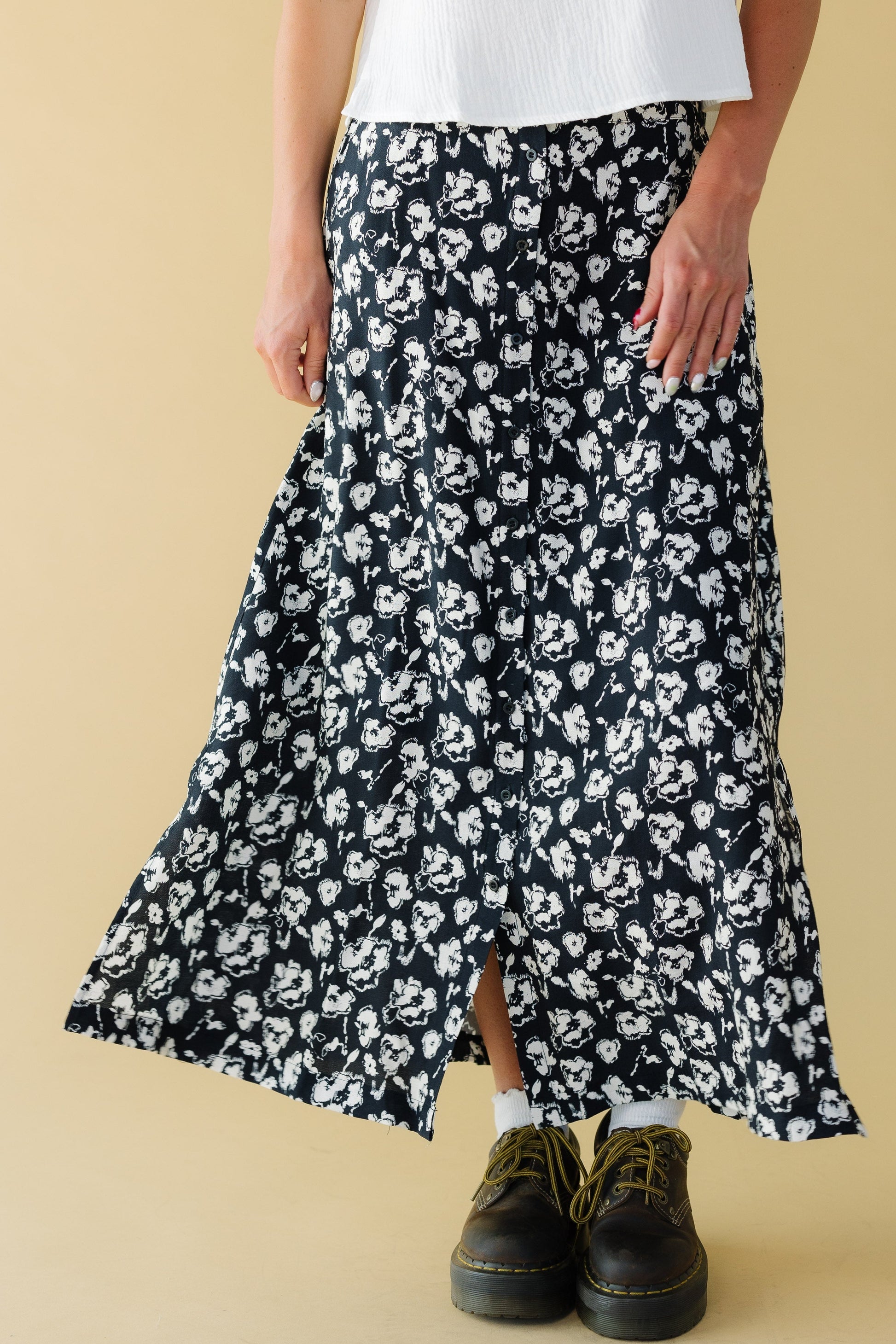 Young woman wearing a modest blck & white button down midi skirt in a black & white floral print.