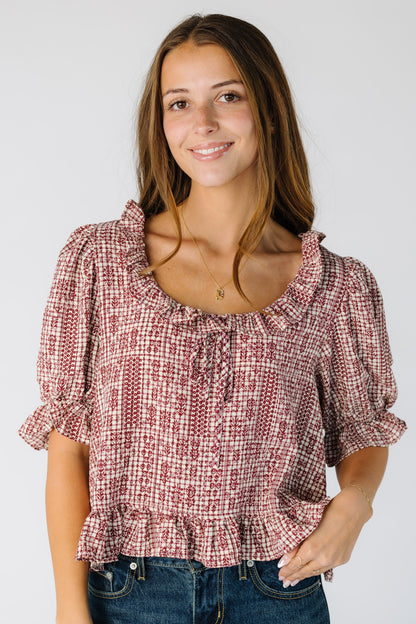 Woman wearing a modest red and white plaid blouse with a scoop neckline and short puff sleeves