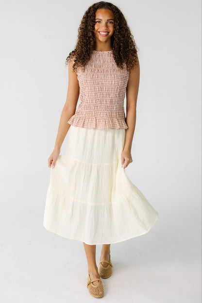 Teenage girl wearing a cream gauzy tiered skirt.