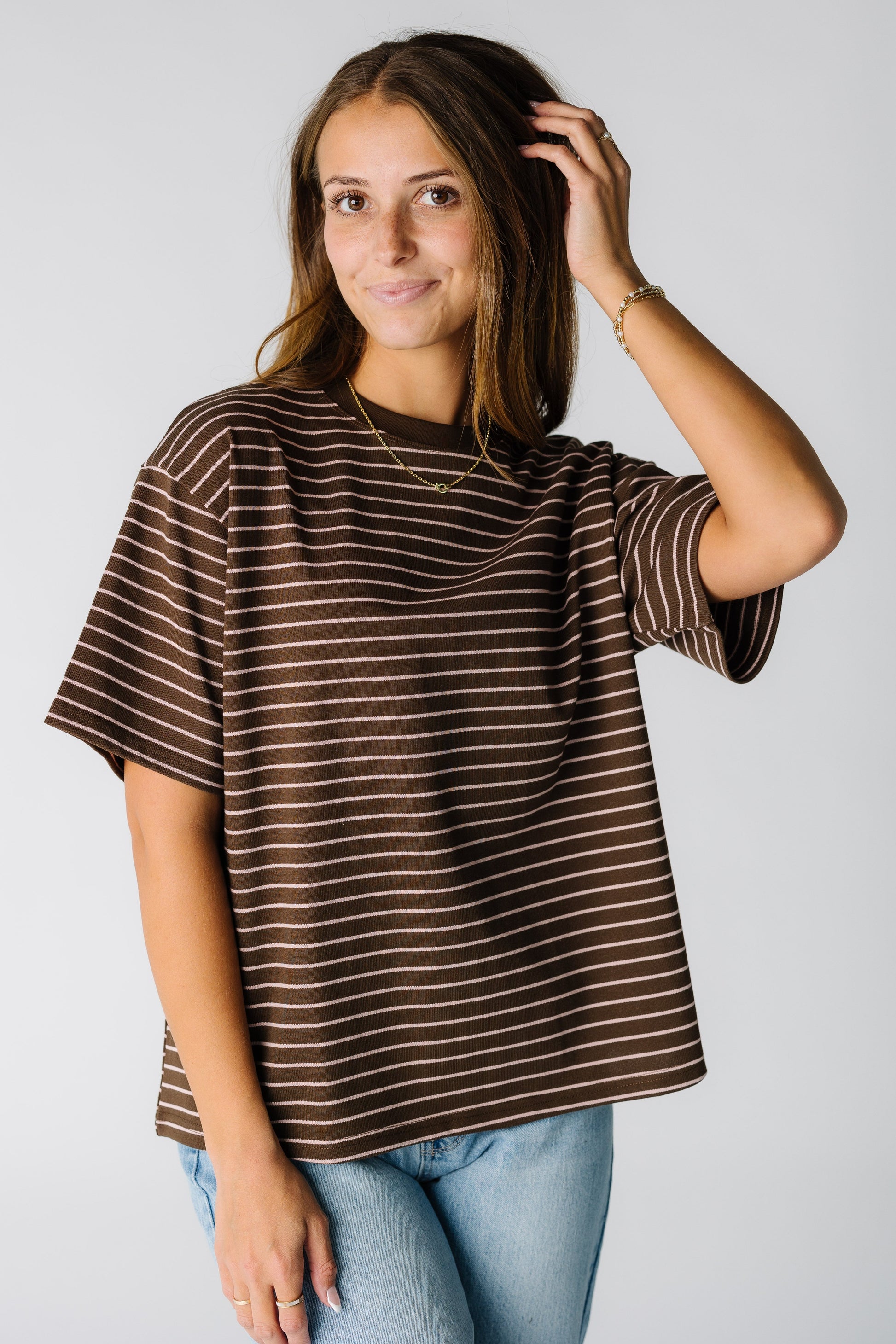 Woman wearing a brown stripe boxy tee with short sleeves