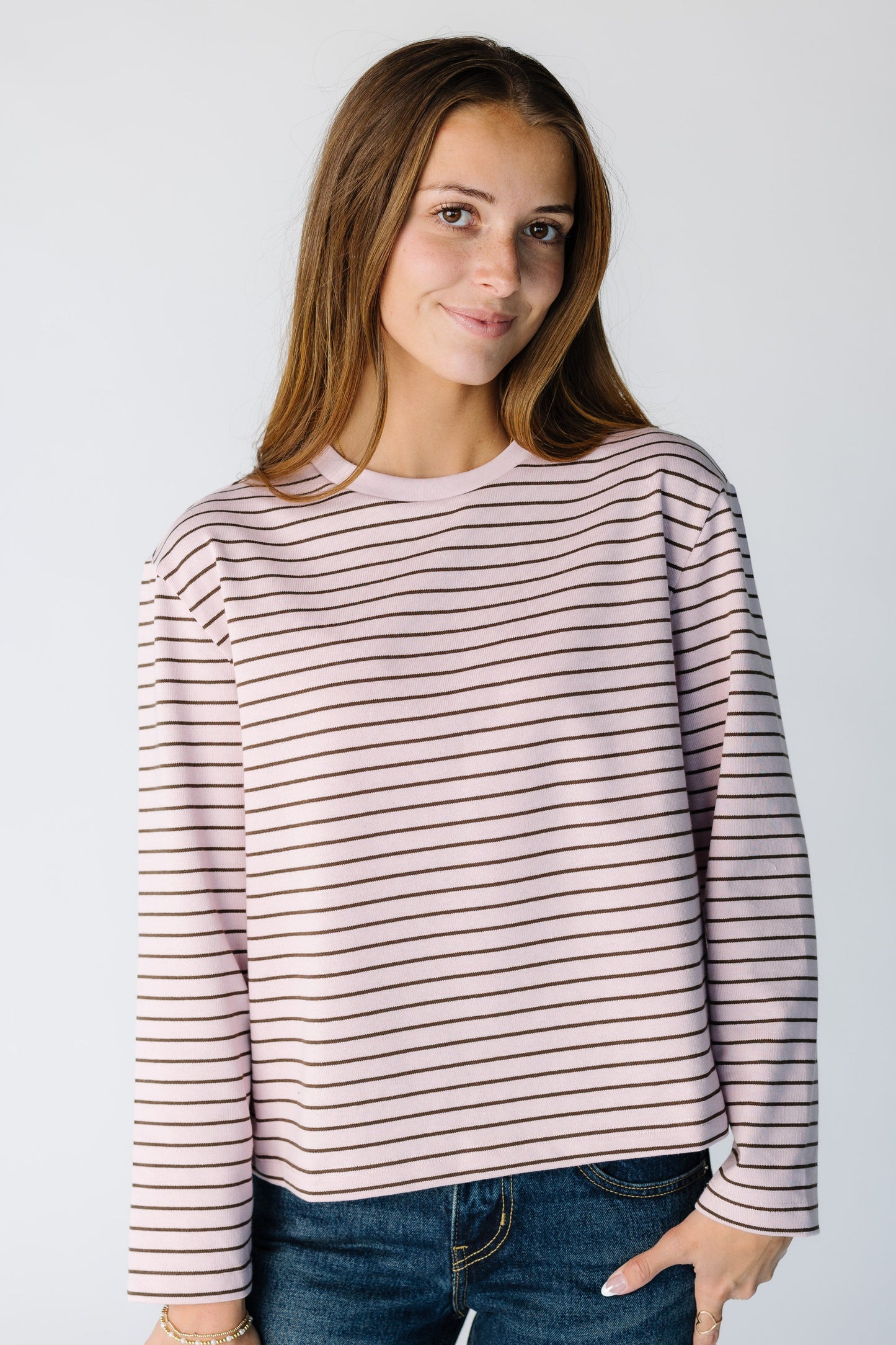 Woman wearing a modest long sleeve stripe tee with a crew neckline in a ink an brown stripe