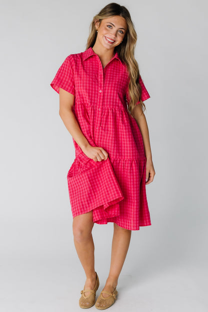 Woman wearing a modest red gingham loose fitting dress with short sleeves.