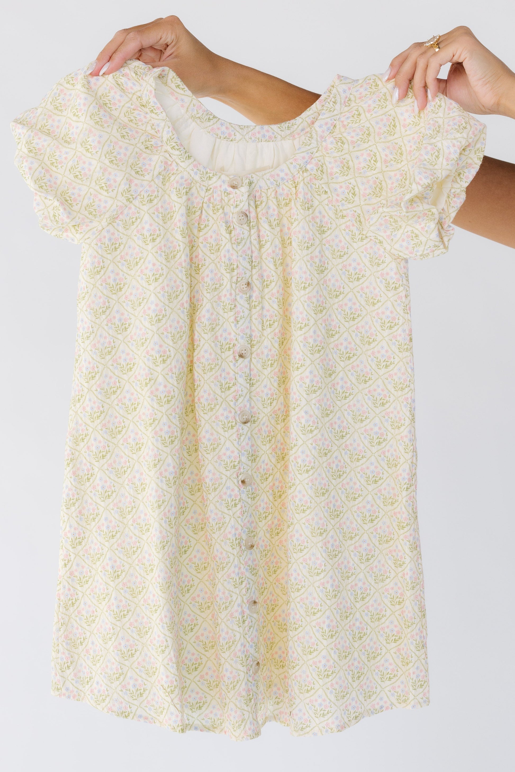 Modest button down girls dress in cream floral with short sleeves.