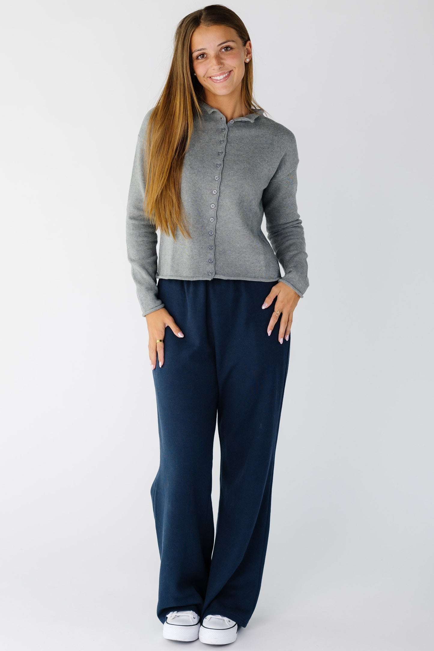 Woman wearing a pair of navy waffle knit pants with a wide cut leg