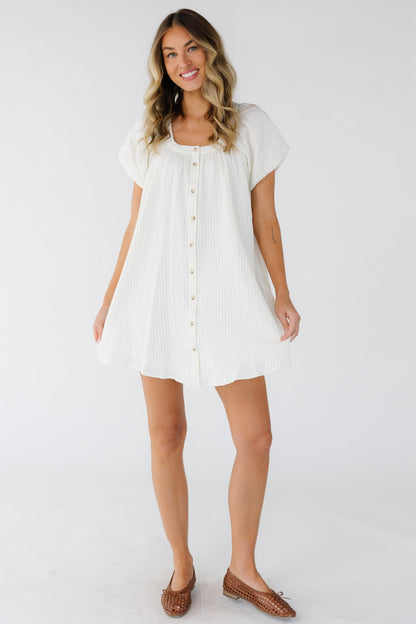 Young woman wearing a white with blue narrow double stripes with a scoop neckline and short puff sleeves.