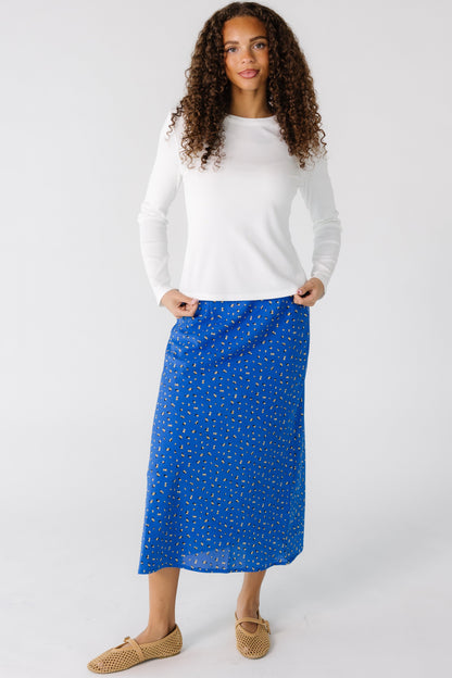 Teen girl wearing a blue floral A-line midi skirt.