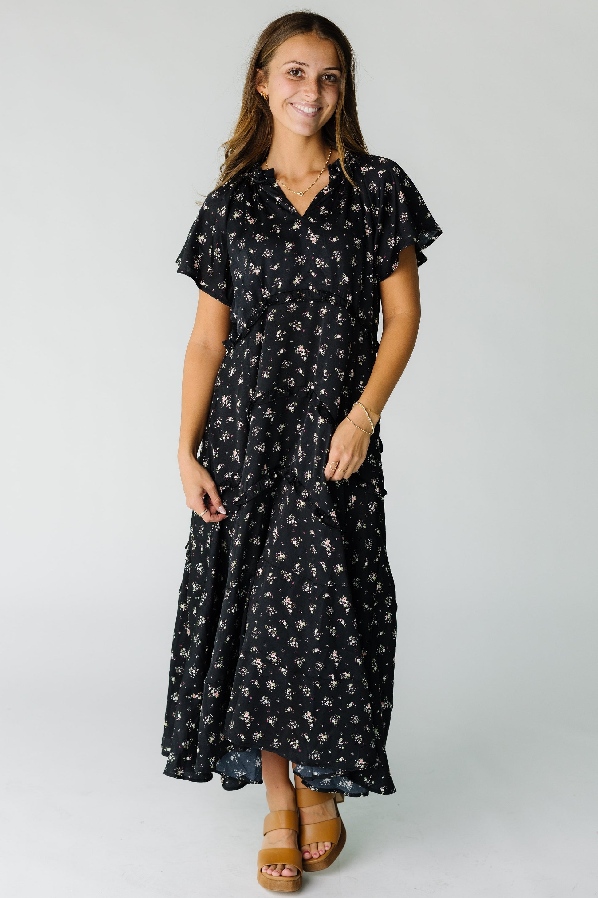 Woman wearing a modest black floral maxi dress with short flutter sleeves