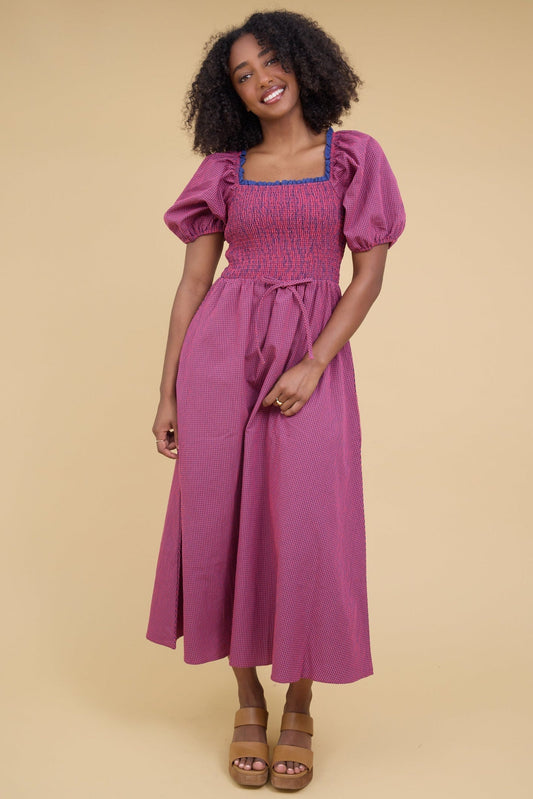 Young woman wearing a modest red & blue gingham midi dress with a smocked bodice and balloon sleeves.