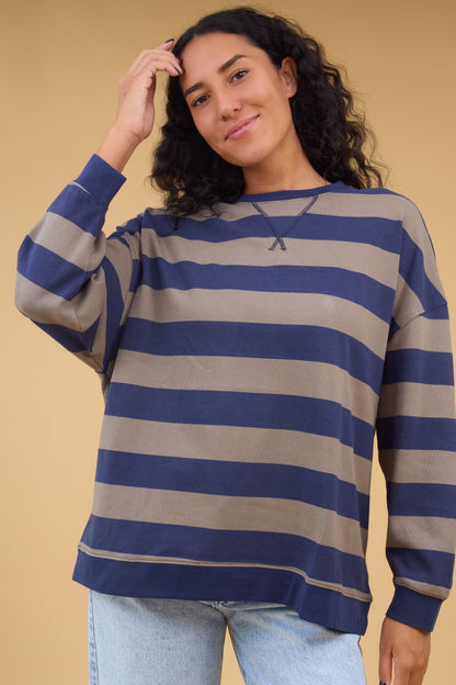 Young woman wearing a modest navy & taupe wide stripe top with long sleeves.