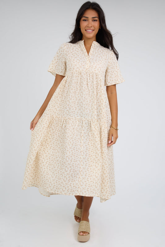 Young woman wearing a modest ivory midi dress with a V-neckline and short sleeves.