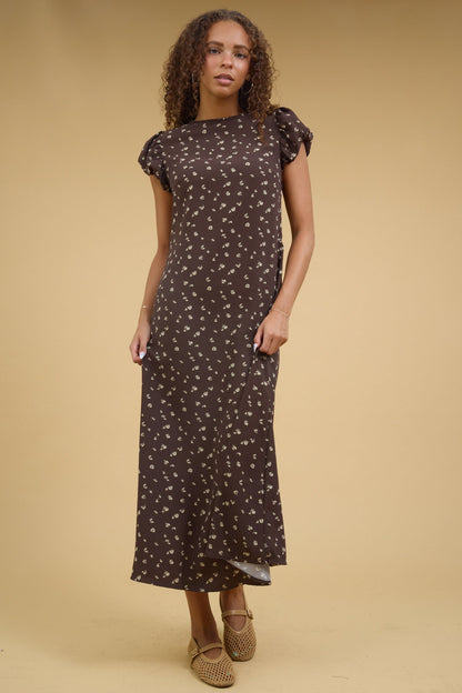 Teenage girl wearing a brown floral print midi dress wtih short gathered cap sleeves.