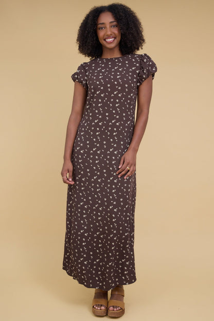 Young woman wearing a close fitting maxi dress with short gathered cap sleeves and a round neckline.