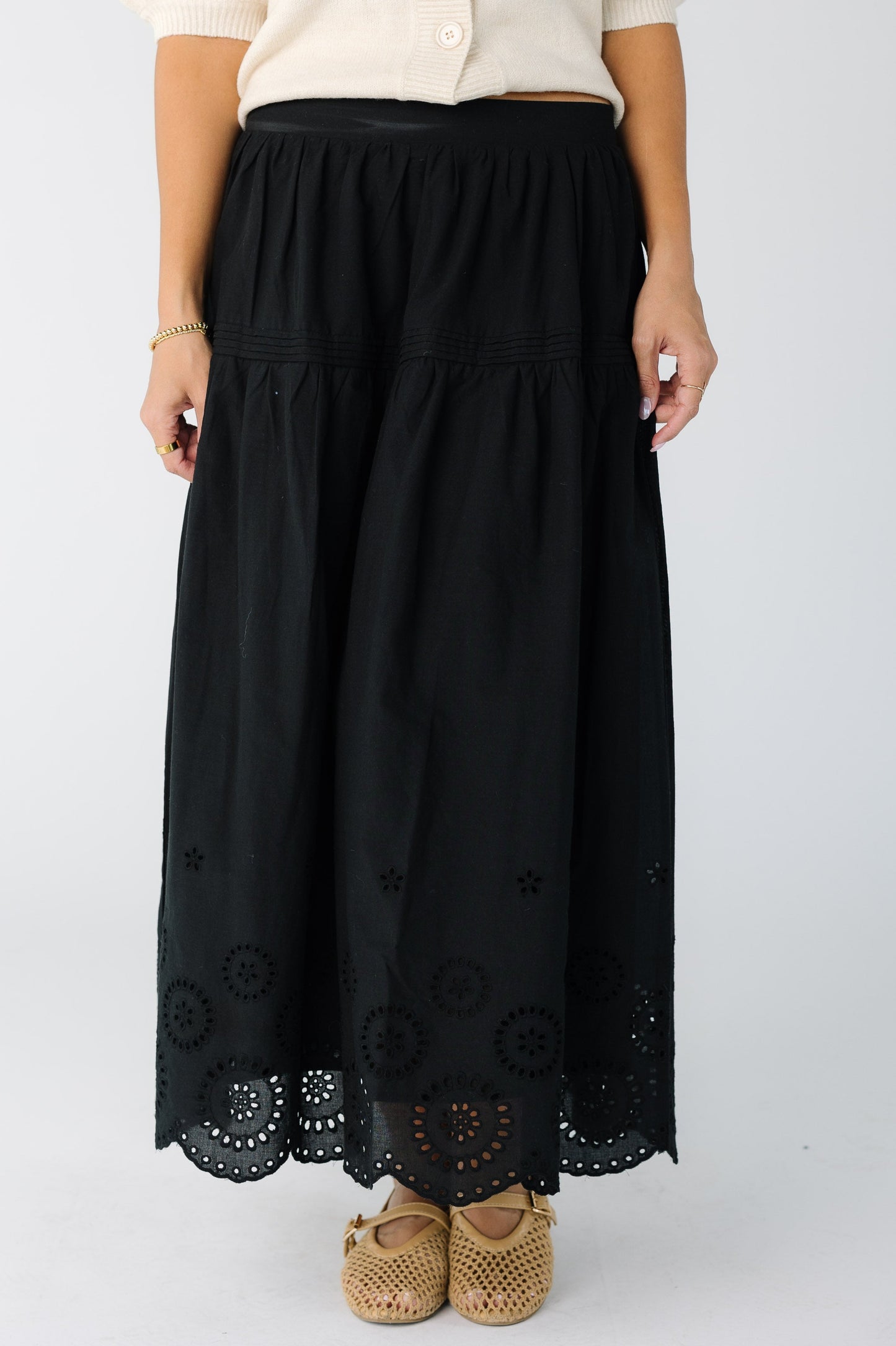 Woman wearing a black midi skirt with eyelet border pattern