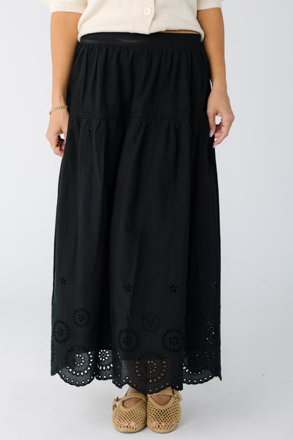 Woman wearing a black midi skirt with eyelet border pattern