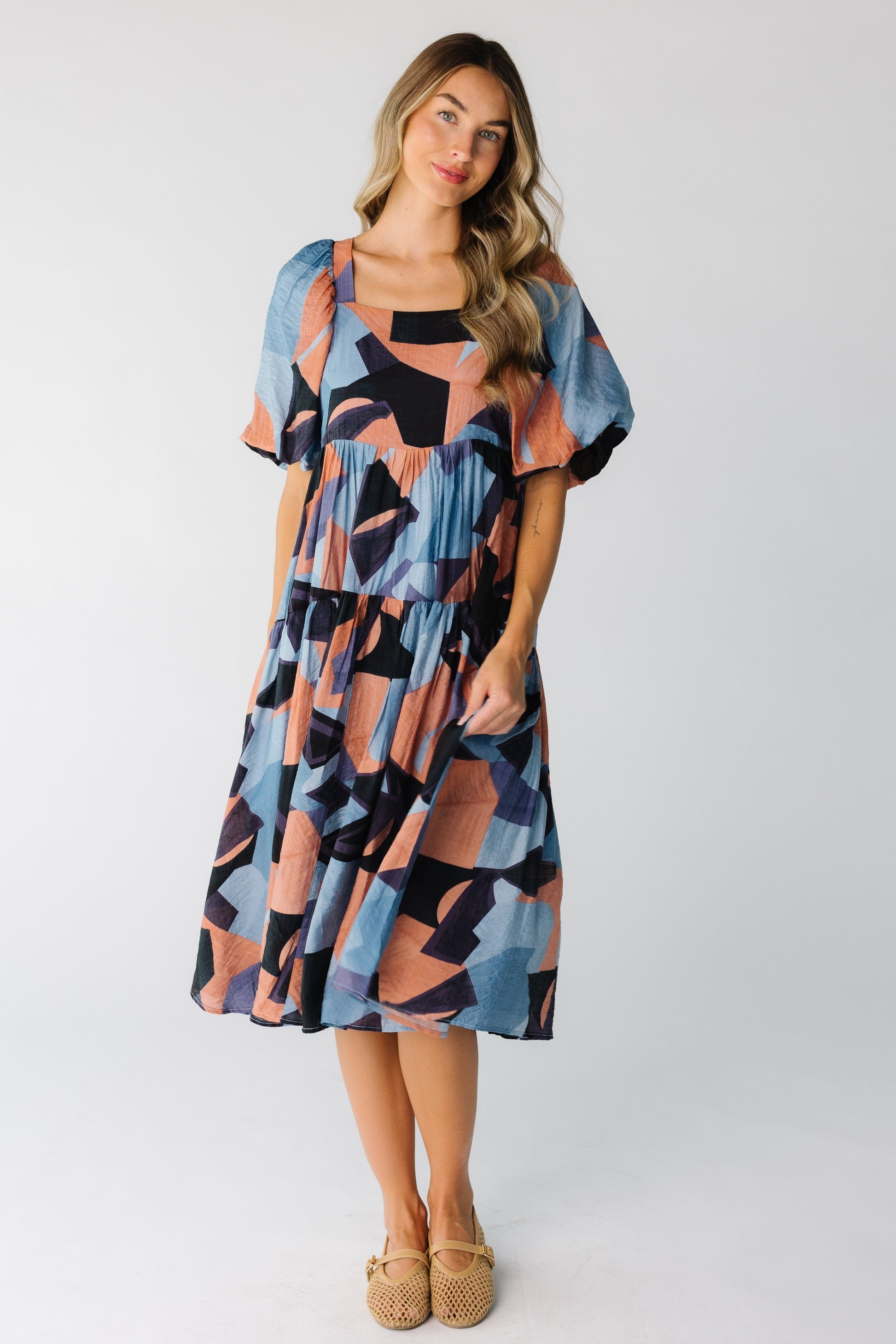Woman wearing colorful dress with large half length sleeves and full skirt