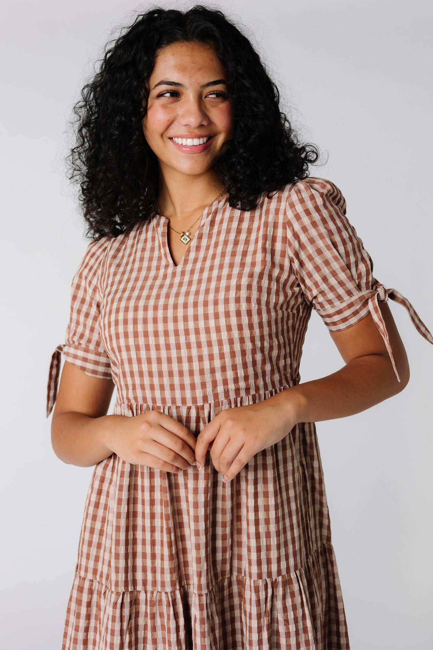 Close view of brown gingham midi dress with notched neckline