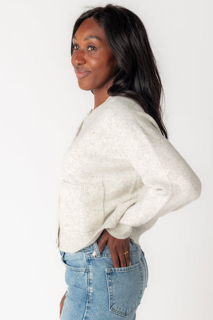 Side view of long sleeve soft light grey cardigan with front patch pockets