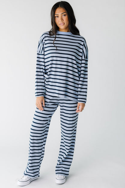 Young woman wearing a light and dark blue stripe lounge set in loose fitting cotton ribbed fabric.