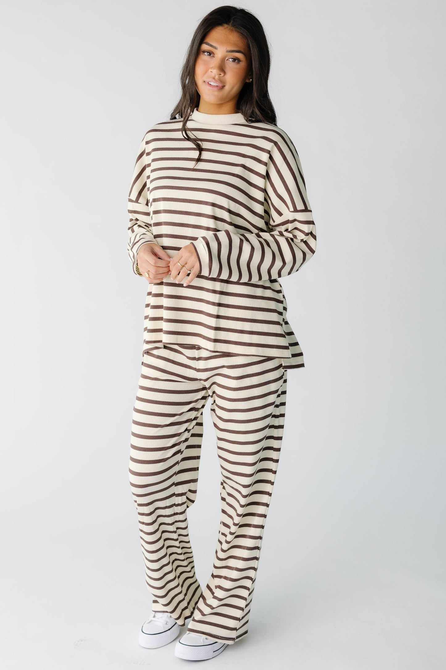 Woman wearing a modest ribbed, cream & brown loose fitting lounge set  with long sleeves and long wide pants.