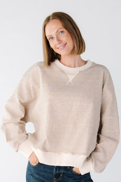 Women wearing a camel and ecru stripe sweatshirt with a solid ecru cuffs
