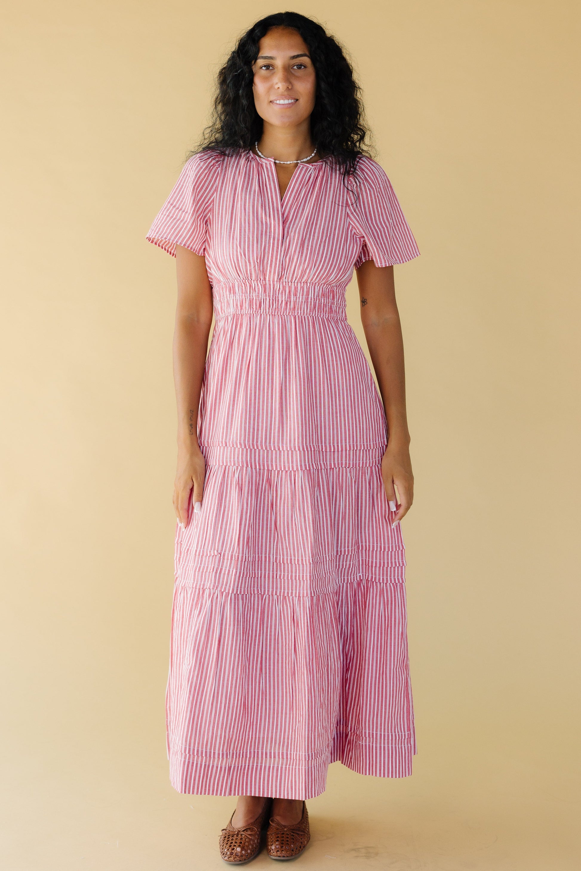 Young woman wearing a  modest red and white narrow stripe midi-maxi dress with a V-neckline and short sleeves.