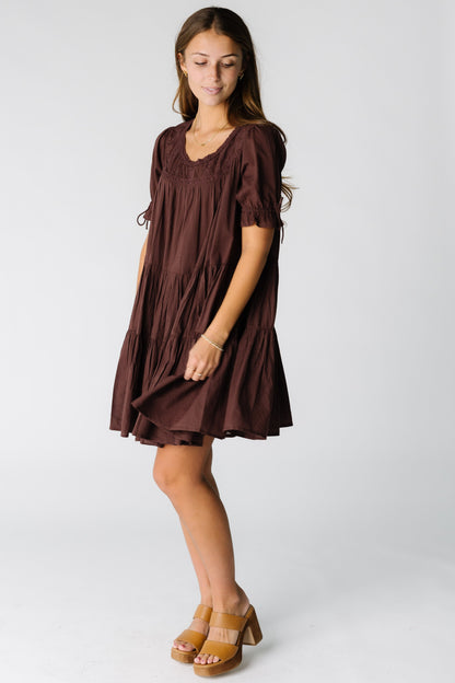 Woman wearing a modest  brown knee length flowy dress with short sleeves