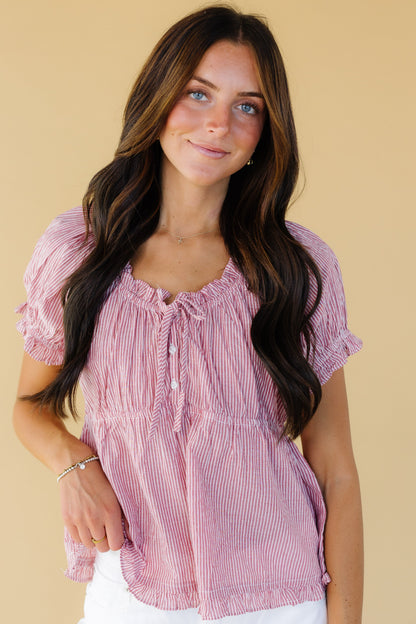 Young woman wearing a modest red stripe top with a drawstring & ruffle scoop neckline, short puff sleeves and and elastic empire waist.