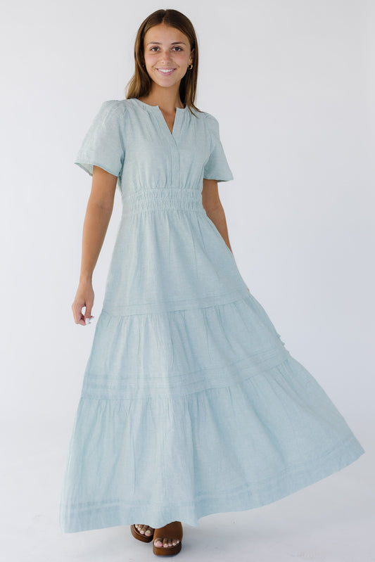 Young woman wearing a green and white stripe midi-maxi dress with a V-neckline, short sleeves, wide 3 band elastic waist and a full gathered and pleated skirt.