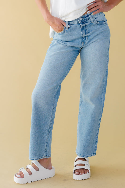 Young woman wearing a modest pair of straight leg jeans in light denim.