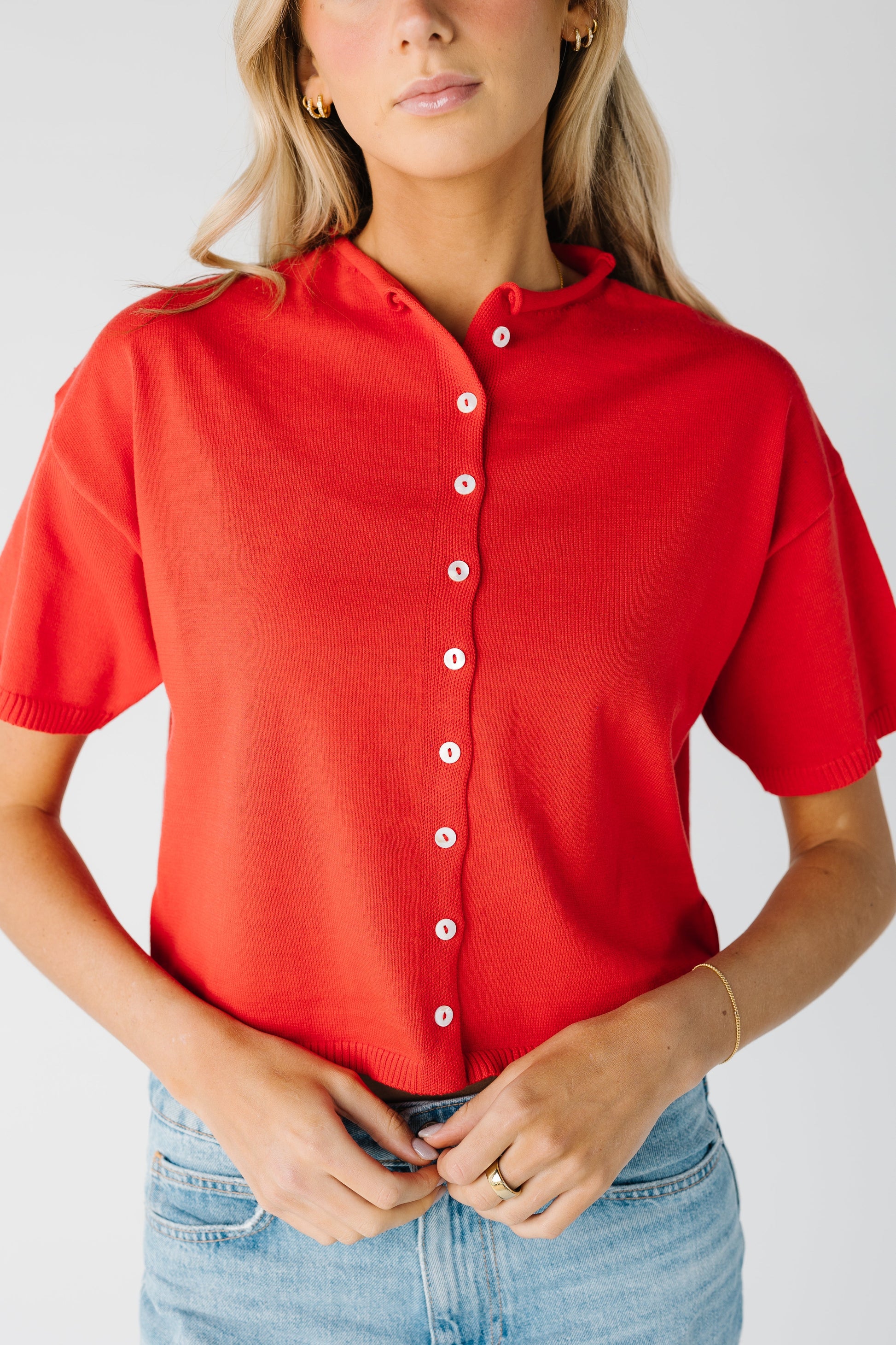 Close view of red knit cardigan with rolled collar 