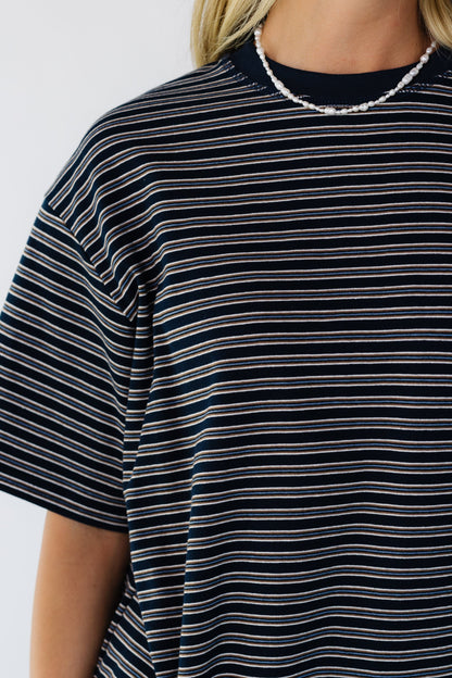 Close viewof a woman wearing a navy short sleeve stripe tee.