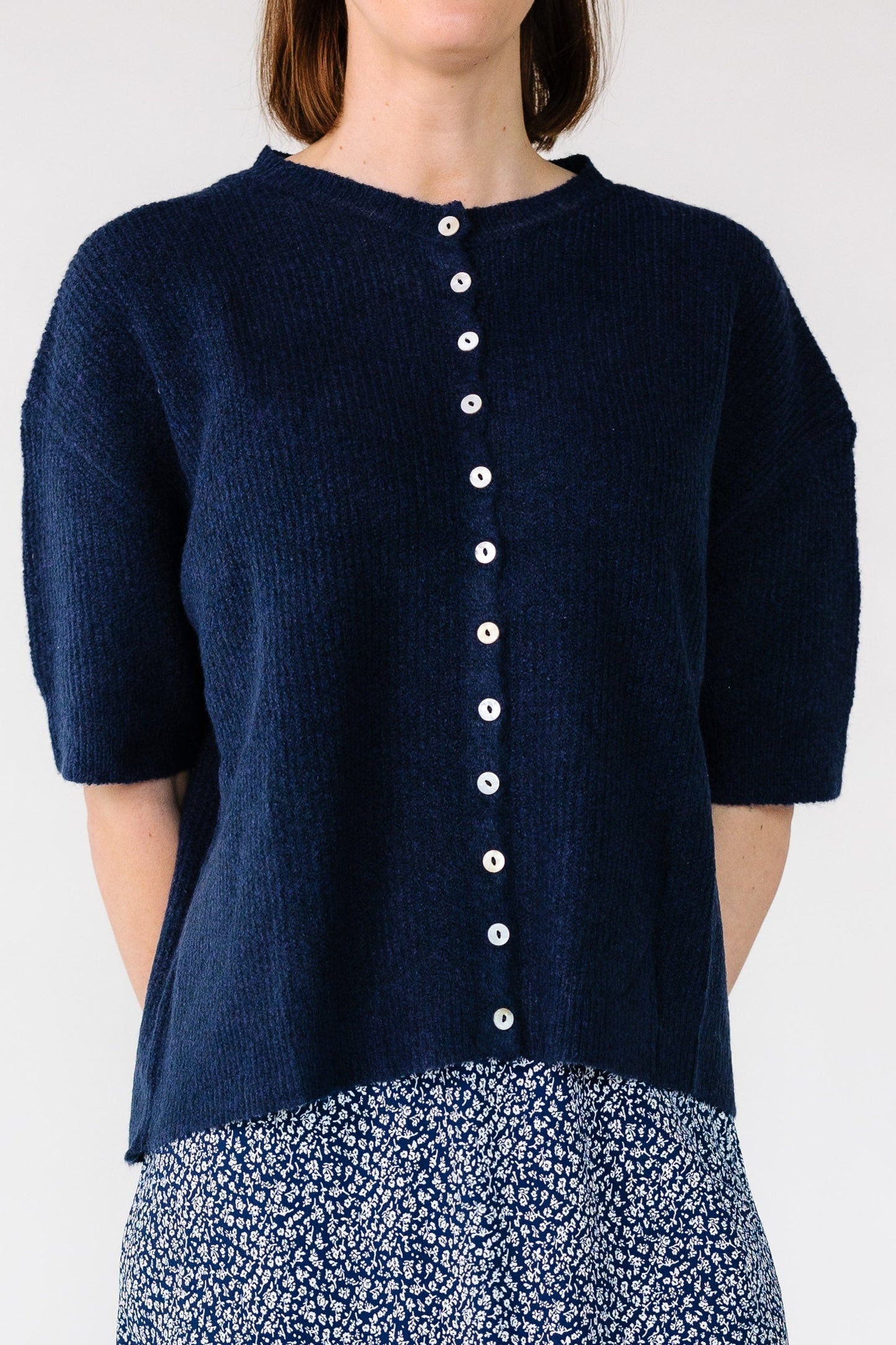 Close view of a woman wearing a modest short sleeve button down cardigan with short sleeves.