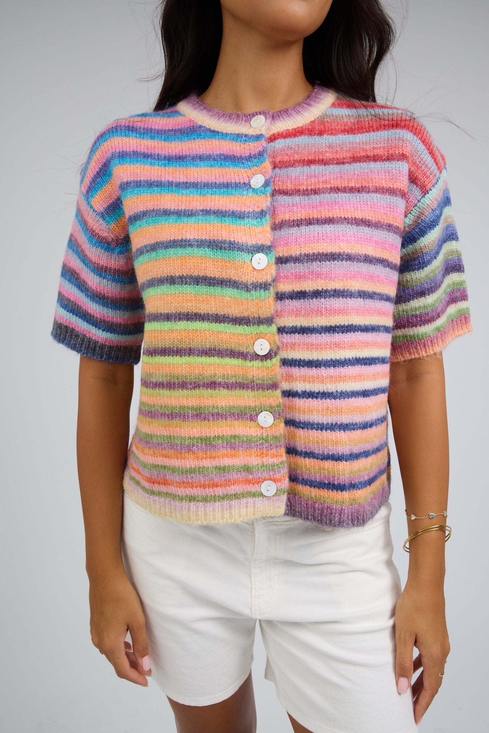 Woman wearing a button down cardigan with short sleeves.