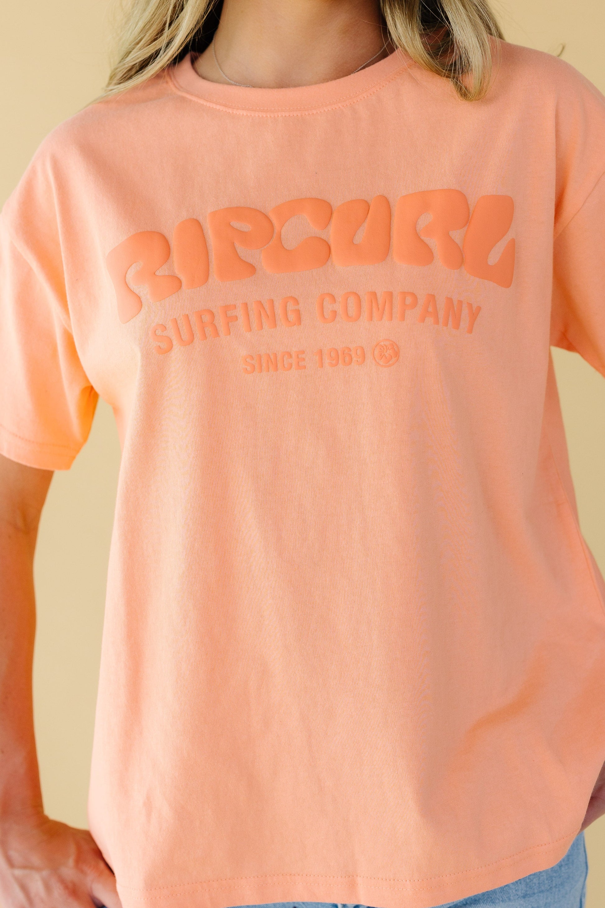 Close view of a young woman wearing a large front graphic tee.