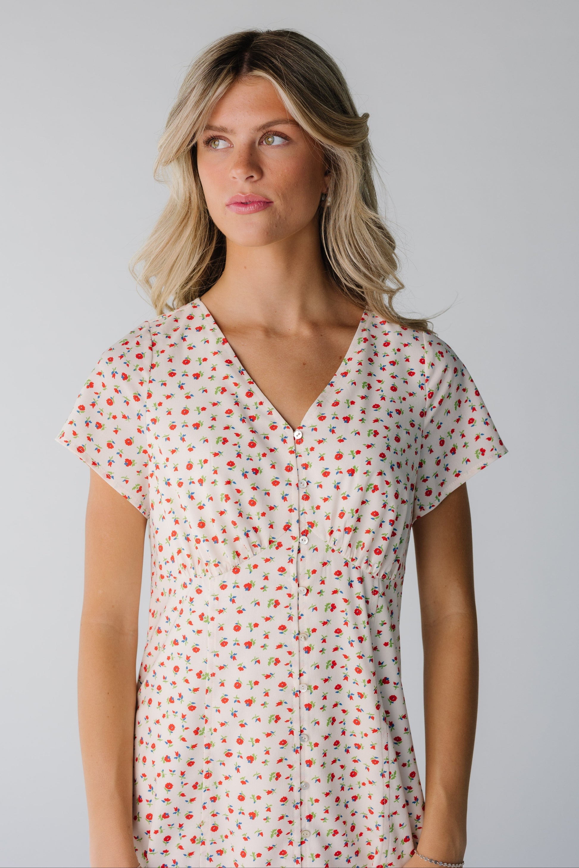 Close view of cream print dress with V-neckline and short sleeves