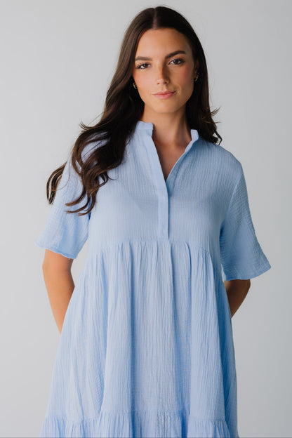 Close view of women's light blue dress with open V-neckline and short sleeves with an empire waist