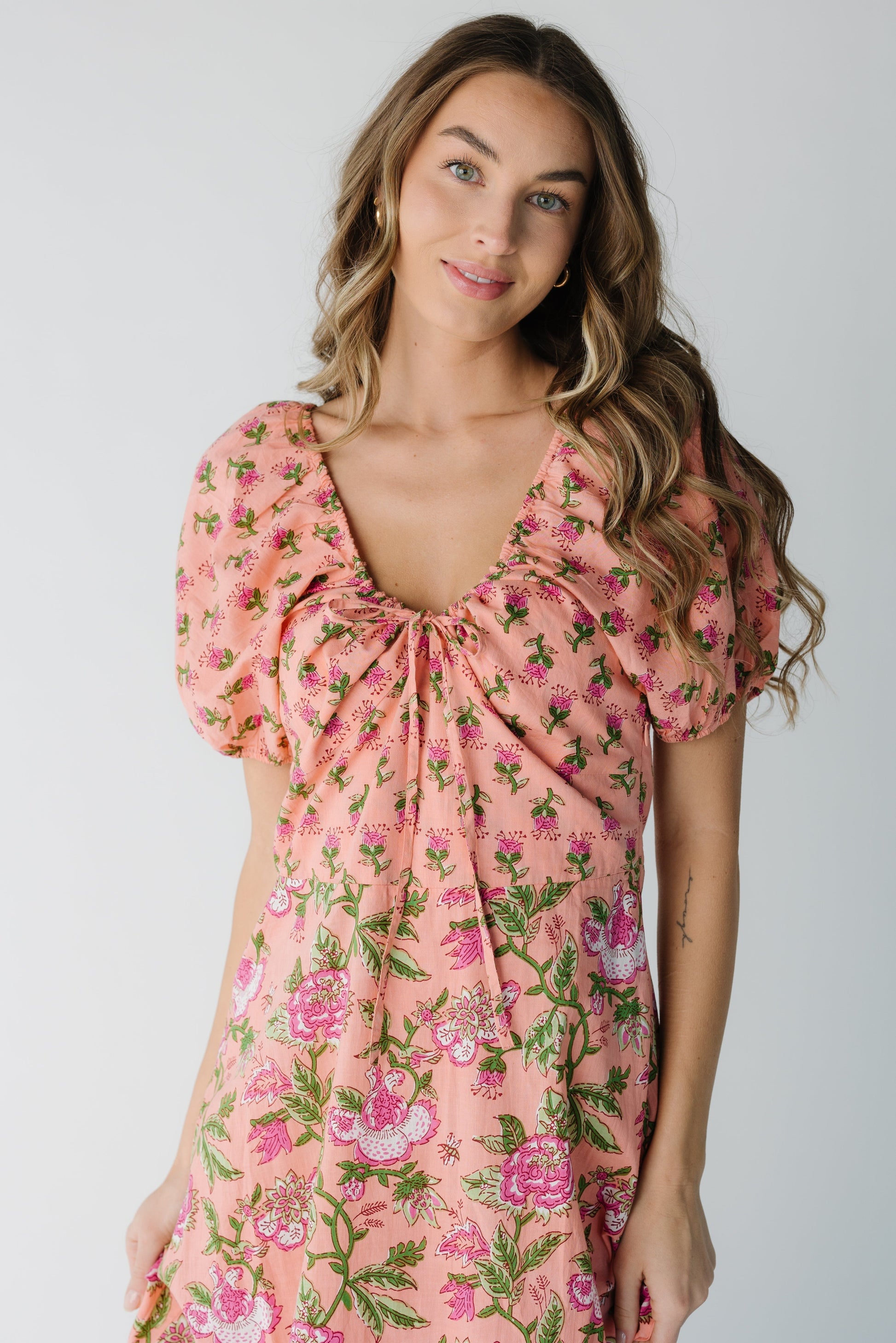 Close view of pink dress with scoop neckline and short puff sleeves