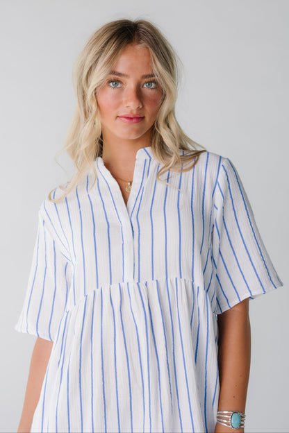 Close view of woman wearing white and blue stripe dress with short sleeves
