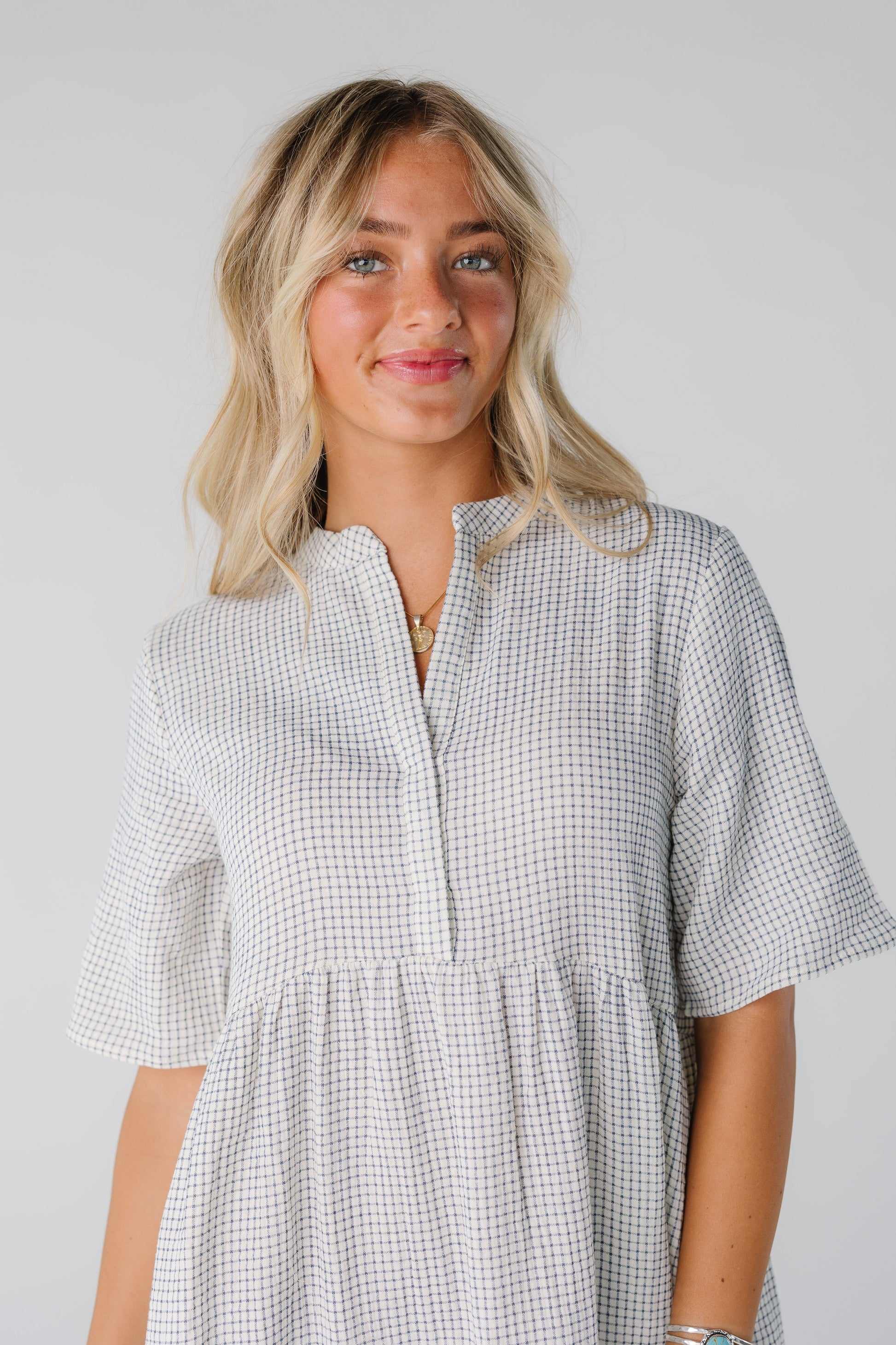 Woman wearing white and black line print top with V-neckline with short sleeves
