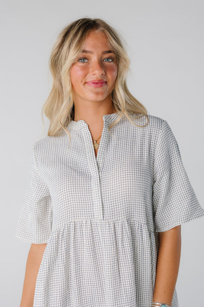 Woman wearing white and black line print top with V-neckline with short sleeves