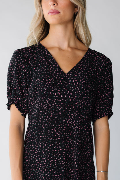 Close view of a woman wearing a black print dress with short sleeves