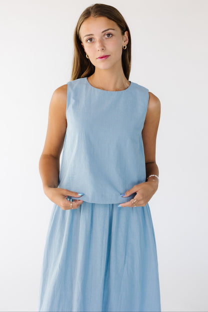 Closer view of a young woman wearing a loose fitting sleeveless dress with a full gathered skirt.