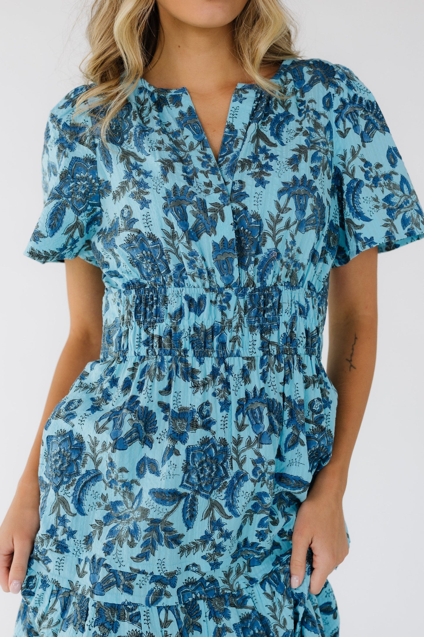 Close view of a woman with a wide elastic waist, short sleeves and a full skirt.