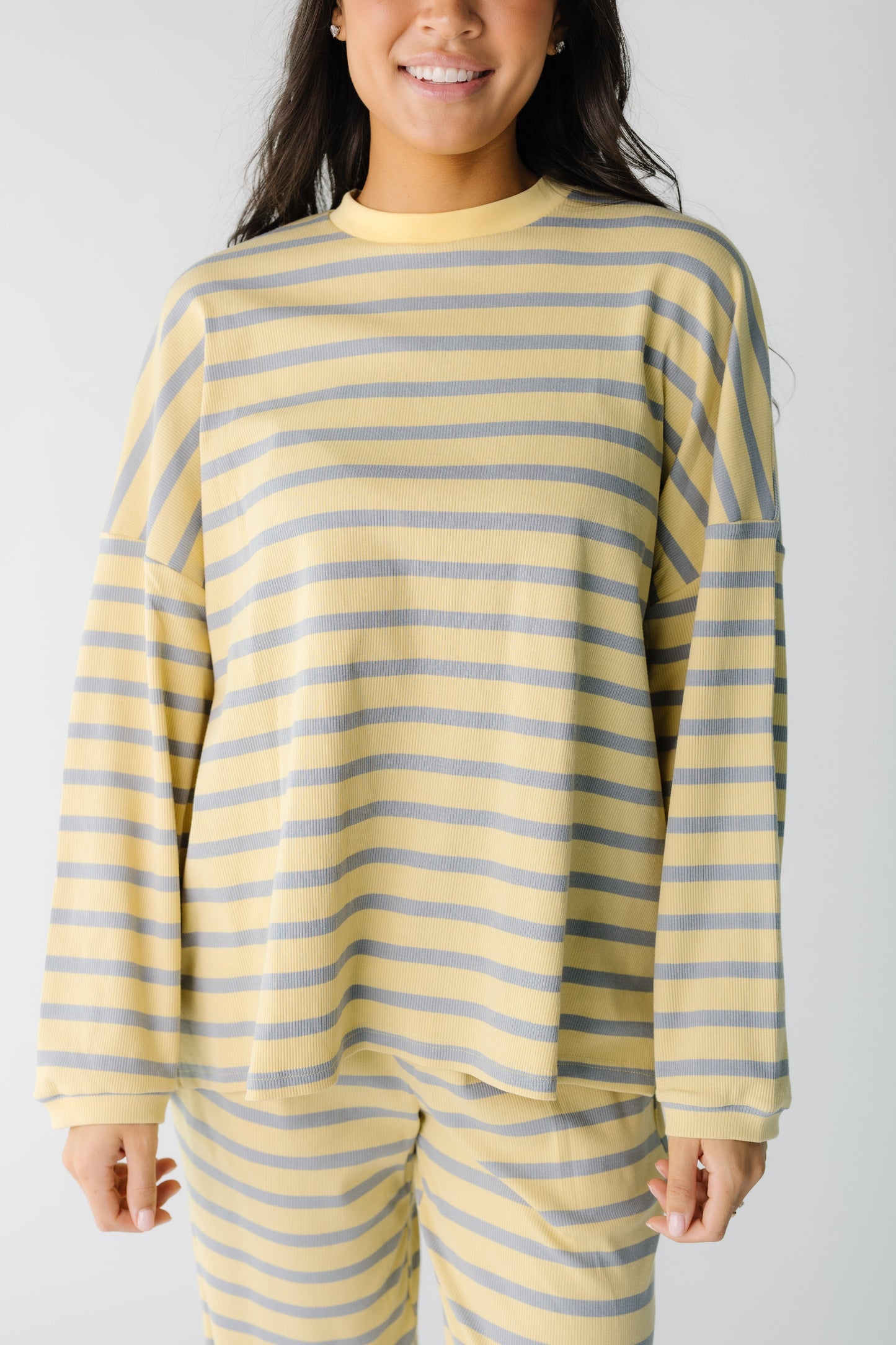 Close view of a woman wearing a yellow and blue stripe lounge top.
