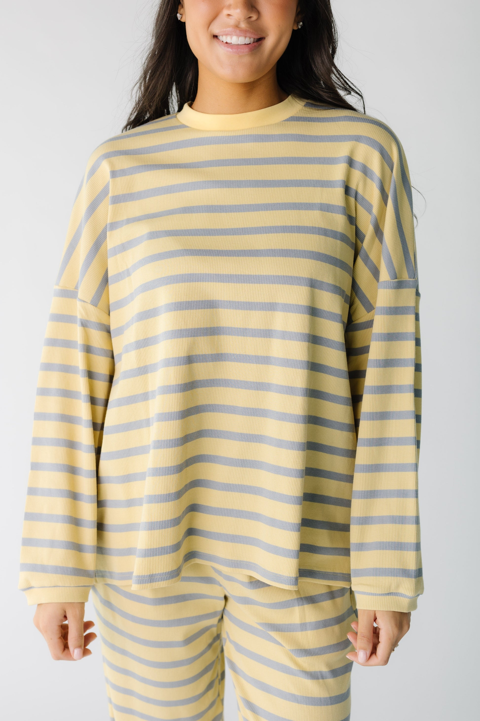 Close view of a woman wearing a yellow and blue stripe lounge top.
