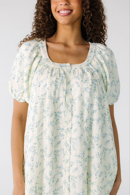 Teenage cream, textured button down dress with blue floral print and short puff sleeves.