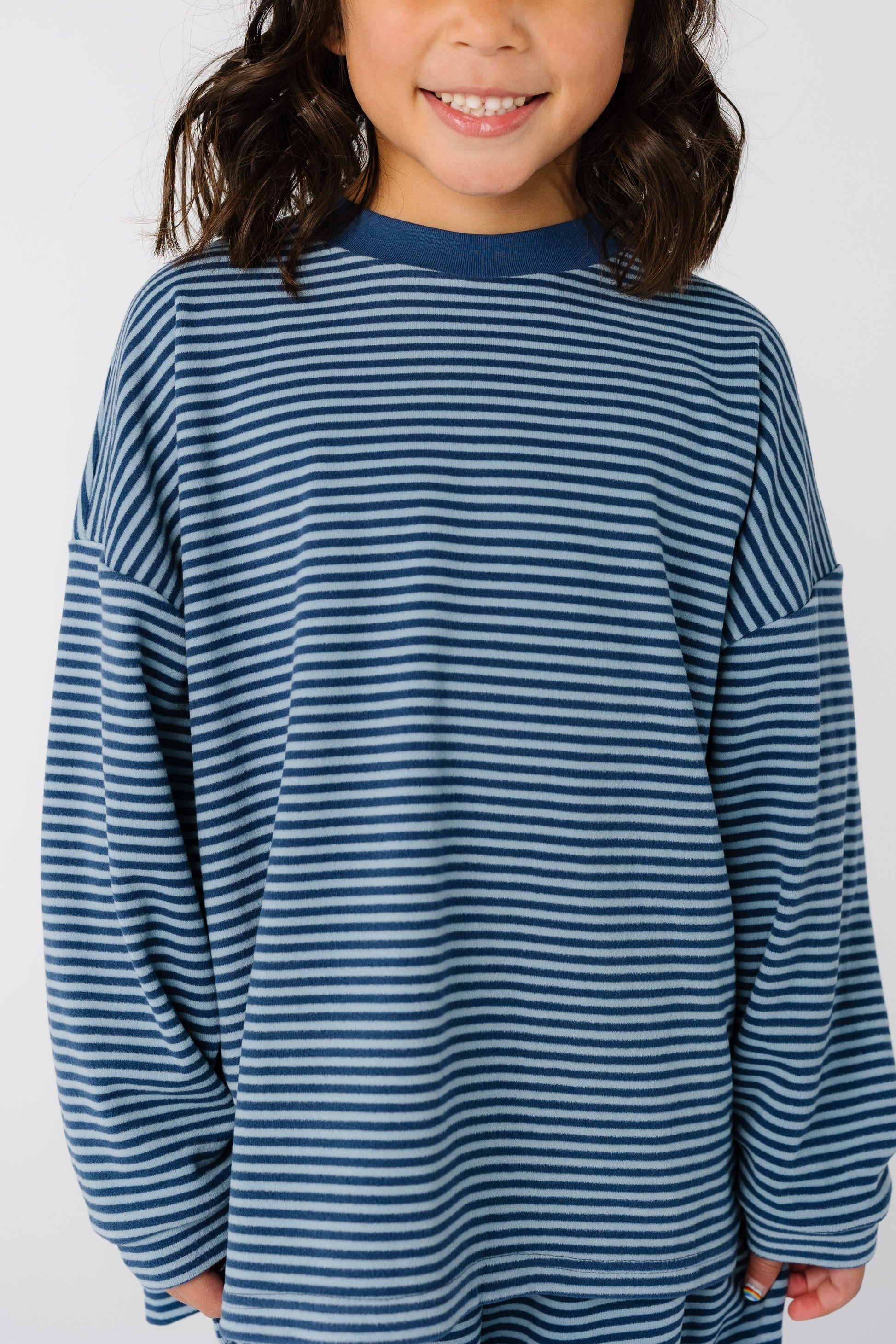 Close view of a girl earing a blue stripe top with long sleeves