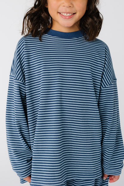 Close view of a girl earing a blue stripe top with long sleeves