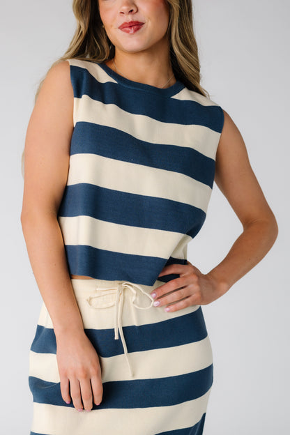 Close view of a woman wearing a a 2 piece skirt and top set in blue and cream stripe.