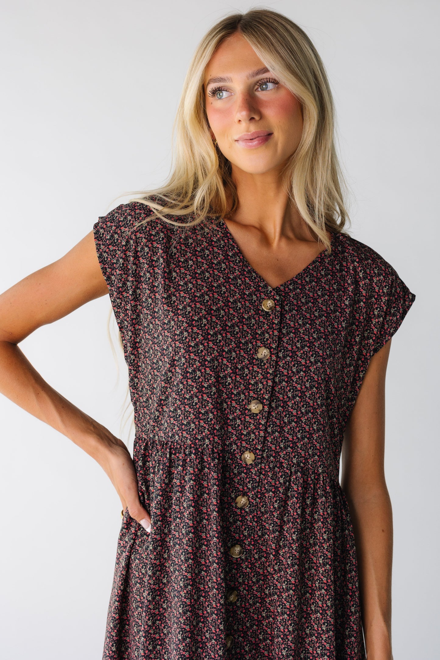 Close view of a woman wearing a black floral button down dress with short sleeves